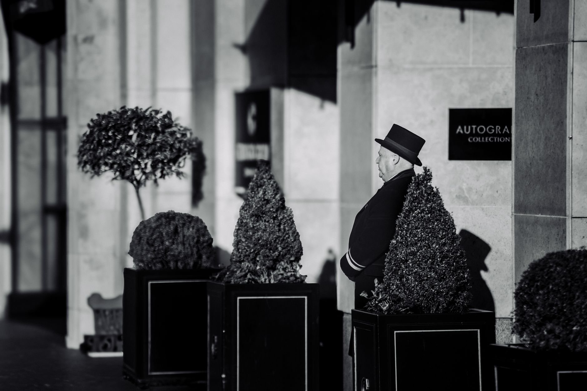 Elegant doorman in formal attire stands in front of luxury hotel in County Dublin.